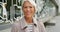 Portrait of smiling senior woman out traveling in the urban city. Confident and positive mature lady with grey hair