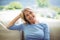 Portrait of smiling senior woman sitting on sofa in living room