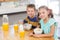 Portrait of smiling sibling having breakfast cereal in kitchen