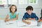 Portrait of smiling siblings studying together in living room