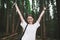 Portrait of a smiling sincere female tourist raising her hands up, holding smartphone, feeling successful, happy and free.