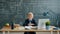 Portrait of smiling smart boy at school desk with chalkboard with formulas in background