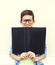 Portrait smiling smart teenager boy in glasses with folder or book