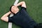 Portrait of a smiling sports man lies on the green grass on football field. The concept of fatigue from outdoor training