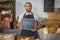 Portrait of smiling staff holding chalkboard with open sign at counter