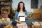 Portrait of smiling staff showing digital tablet at bakery counter