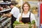 Portrait of smiling staff woman holding a box with fresh vegetables