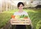 Portrait of a smiling staff woman holding wooden box with fresh