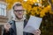 Portrait of a smiling student in casual clothes holding a pen with papers and looking to the side