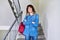 Portrait of smiling student girl with backpack on the stairs inside building