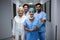 Portrait of smiling surgeons and doctor standing in corridor