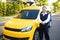 Portrait of smiling taxi driver with car