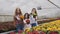 Portrait of smiling three girls stretching synchronously flower pots