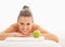 Portrait of smiling woman with apple laying on massage table