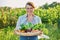 Portrait of smiling woman with basket of different fresh vegetables and herbs