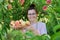 Portrait of smiling woman with basket of fresh peaches, tree with ripe peaches background