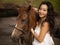 Portrait of smiling woman and brown horse. Asian woman hugging horse. Romantic concept. Love to animals. Nature concept. Bali