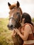 Portrait of smiling woman and brown horse. Asian woman kissing horse. Romantic concept. Positive emotions. Love to animals. Nature