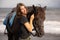 Portrait of smiling woman and brown horse. Young Caucasian woman hugging horse. Romantic concept. Love to animals. Nature concept