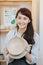 Portrait of a smiling woman with a clay bowl in her hands