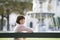 Portrait Of Smiling Woman In Front Of Blurred Fountain