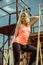 Portrait of smiling woman in an orange T-shirt is standing on rusty steps