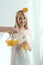 portrait of smiling woman with piece of orange on head pouring juice into glass vegan