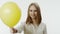 Portrait of smiling woman with yellow balloon