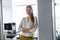 Portrait of smiling young businesswoman with arms crossed in doorway of office