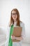 Portrait of a smiling young female doctor with medical gown and clipboard. Good healthcare concept