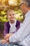 portrait smiling young granddaughter with her disabled grandfather in wheelchair.