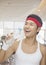 Portrait of smiling young man drinking from water bottle at the gym