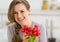 Portrait of smiling young woman with bunch of radishes