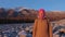 Portrait of a smiling young woman at the foot of the mountains at sunset