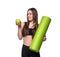 Portrait of smiling young woman holding rolled up exercise yoga mat and green apple isolated on white background.