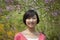 Portrait of smiling young woman with medium length hair outdoors in the park in springtime