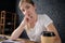 Portrait of SMM manager. Young woman sits behind desk with pen in the hand and paper coffee cup