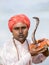 Portrait snake charmer adult man in turban and cobra sitting near the lake. Pokhara, Nepal