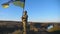 Portrait of soldier in military uniform lifted up flag of Ukraine in hill. Ukrainian army man holding waving flag