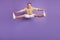 Portrait of sportive active flexible guy jump hands touch legs on purple background