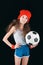 Portrait of sportive girl with soccer ball isolated on black