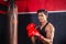 Portrait of Sportsman muay thai boxer fighting in gym, muscular handsome boxing man fighter with boxing bag