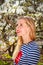 Portrait of spring blonde girl standing in blooming garden