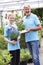 Portrait Of Staff At Garden Center Holding Plants