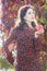 Portrait of standing autumn girl in fall head wreath with red apple in arm