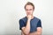 Portrait of stressed blond man with eyeglasses thinking and looking down