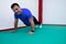 Portrait of a strong determined young man doing push-ups and looking at camera