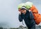 Portrait of strong Sherpa man working as porter carrying a huge cargo with traditional method on forehead. High Himalayas