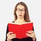 Portrait of student girl in glasses shocked looking in book