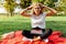 Portrait of a student with glasses who is tired of studying sitting on a red blanket in the Park